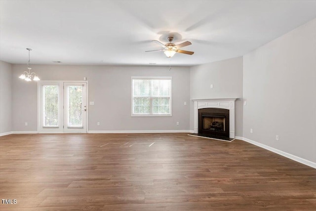 202 Verrazano Pl, Clayton, NC 27520 - unfurnished living room featuring ceiling fan, a chandelier, a fireplace with raised hearth, wood finished floors, and baseboards