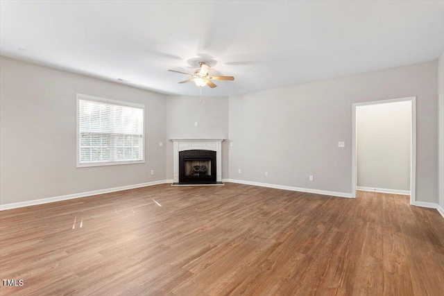 202 Verrazano Pl, Clayton, NC 27520 - unfurnished living room with a ceiling fan, wood finished floors, a fireplace with raised hearth, and baseboards