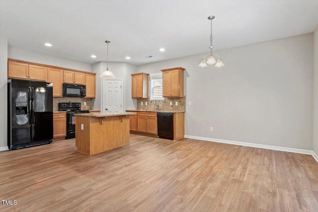 202 Verrazano Pl, Clayton, NC 27520 - kitchen featuring black appliances, light wood finished floors, decorative backsplash, a sink, and recessed lighting
