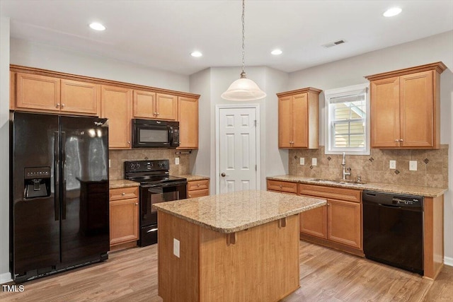 202 Verrazano Pl, Clayton, NC 27520 - kitchen featuring black appliances, a sink, a center island, light wood-style floors, and recessed lighting