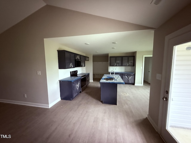 72 Ruskin Dr, Smithfield, NC 27577 - kitchen featuring black range with electric cooktop, lofted ceiling, light wood-style flooring, an island with sink, and baseboards