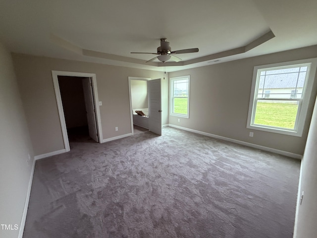 72 Ruskin Dr, Smithfield, NC 27577 - unfurnished bedroom featuring a tray ceiling, carpet flooring, and baseboards