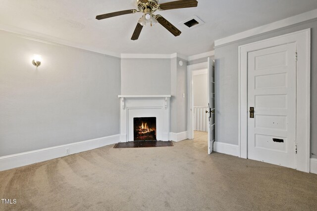 unfurnished living room with ceiling fan, a fireplace with flush hearth, baseboards, ornamental molding, and carpet flooring