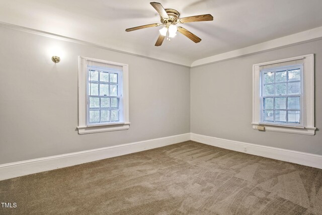 unfurnished room with a healthy amount of sunlight, carpet floors, baseboards, and a ceiling fan