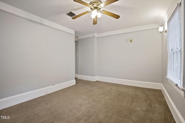 carpeted empty room featuring baseboards, a wealth of natural light, a ceiling fan, and visible vents