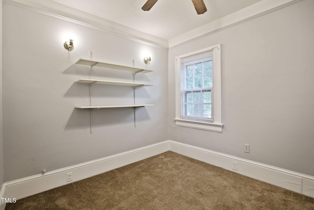 carpeted spare room with ceiling fan and baseboards