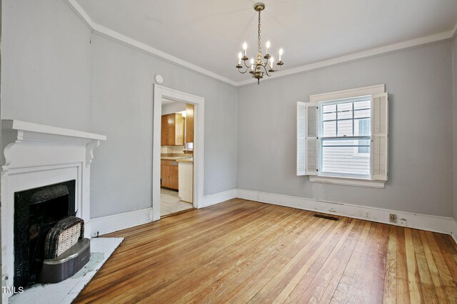 unfurnished living room featuring an inviting chandelier, baseboards, light wood-style floors, and a fireplace with raised hearth