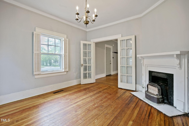unfurnished living room with visible vents, wood-type flooring, a chandelier, and french doors