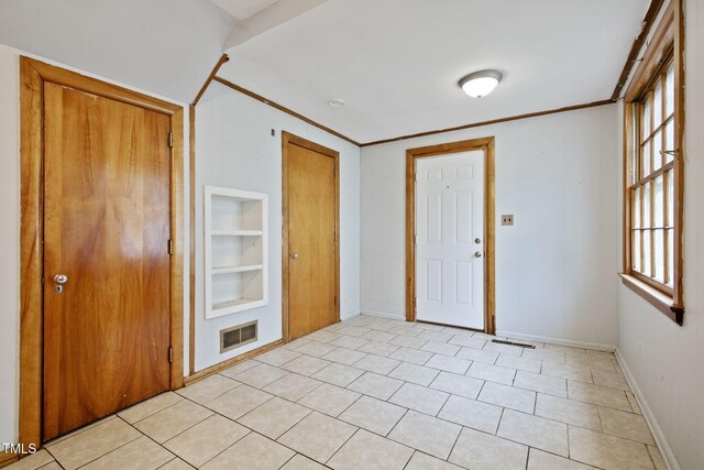 entrance foyer featuring crown molding, baseboards, and visible vents