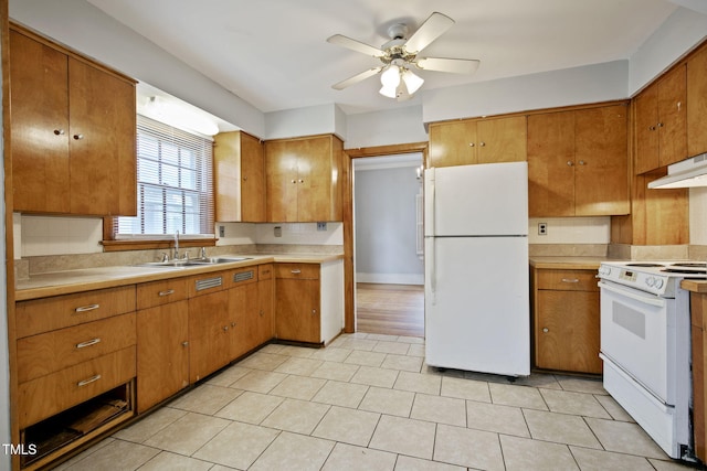 kitchen with brown cabinets, a sink, white appliances, light countertops, and a ceiling fan