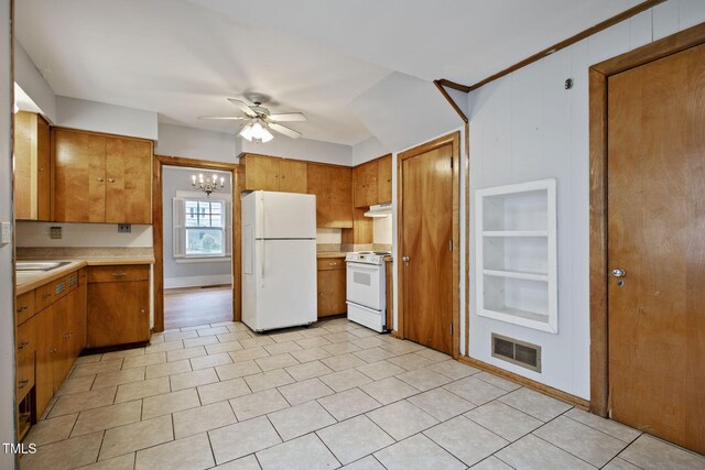 kitchen with white appliances, light countertops, brown cabinetry, ceiling fan with notable chandelier, and visible vents