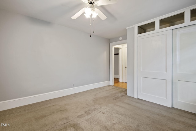 unfurnished bedroom with a closet, carpet flooring, baseboards, and ceiling fan