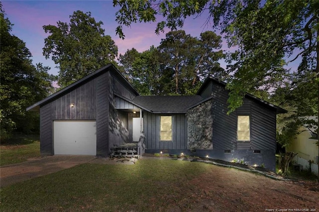 mid-century inspired home with an attached garage, a front lawn, and concrete driveway
