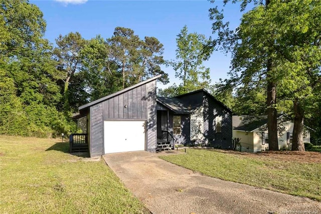 mid-century modern home featuring a garage, a front lawn, and driveway