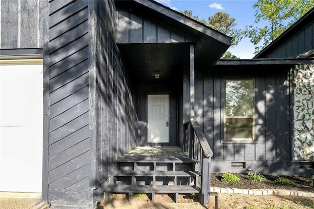 doorway to property featuring board and batten siding and crawl space