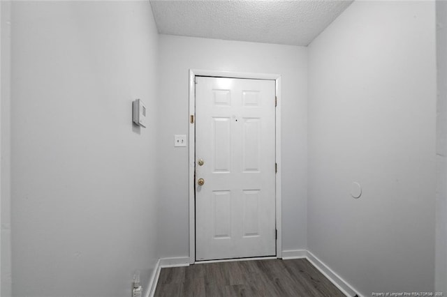 entryway featuring baseboards, dark wood-style floors, and a textured ceiling
