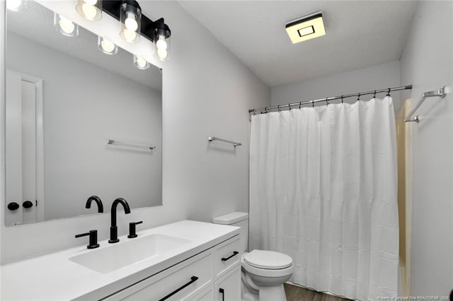 full bathroom featuring vanity, curtained shower, toilet, and wood finished floors