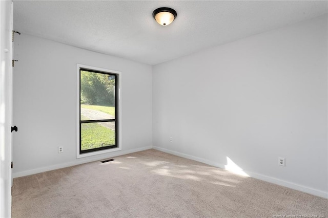 carpeted empty room with baseboards and visible vents