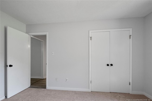 unfurnished bedroom featuring a closet, baseboards, and carpet flooring