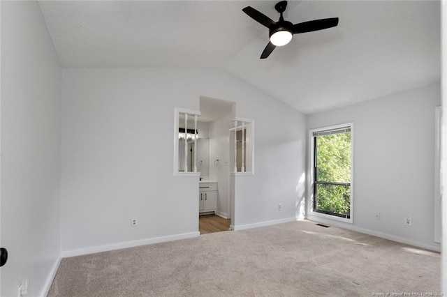 unfurnished bedroom featuring connected bathroom, carpet, baseboards, vaulted ceiling, and visible vents