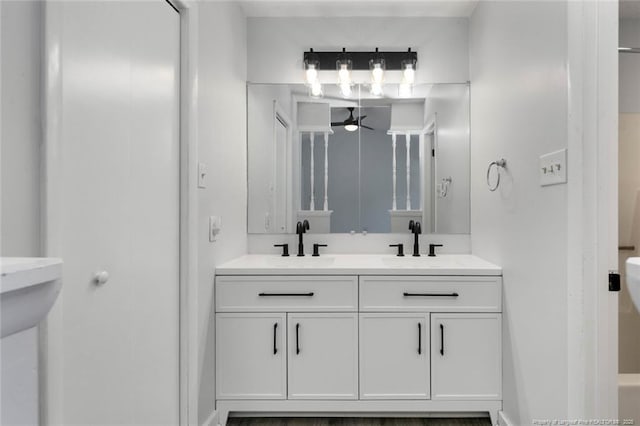 full bath featuring double vanity, a sink, and a ceiling fan