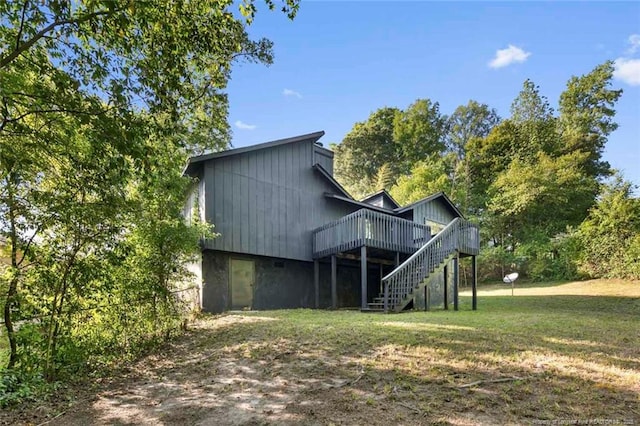 back of property featuring stairs, a lawn, and a wooden deck