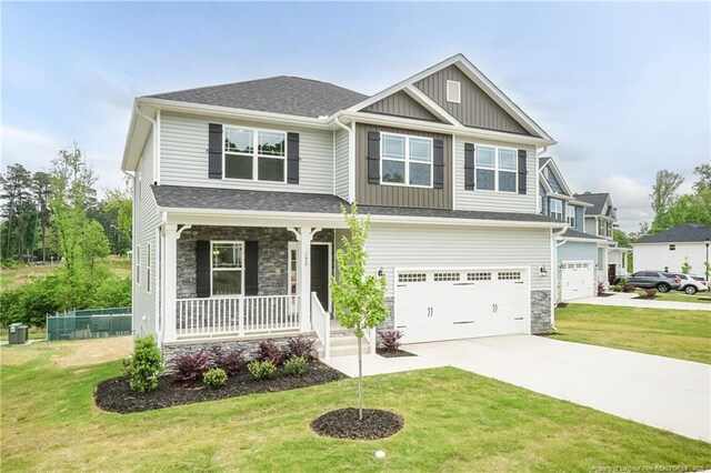 craftsman-style home featuring board and batten siding, concrete driveway, stone siding, covered porch, and an attached garage