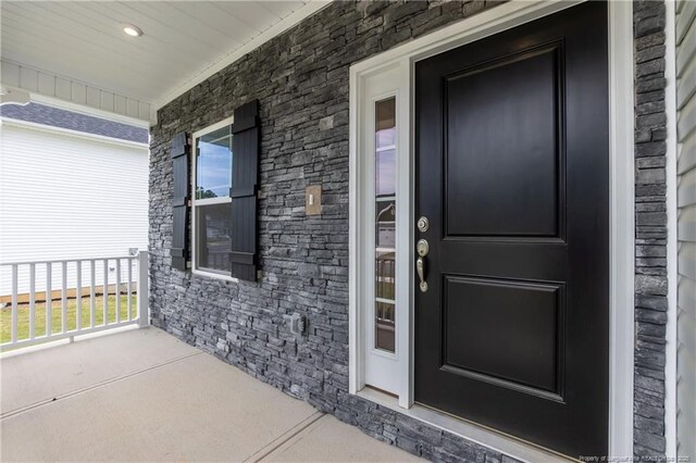 view of exterior entry featuring covered porch