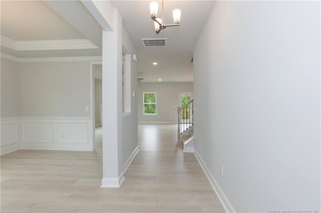 corridor with recessed lighting, light wood-style flooring, a chandelier, ornamental molding, and visible vents