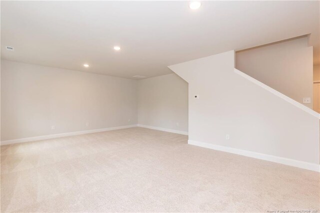 unfurnished room featuring recessed lighting, light colored carpet, and baseboards