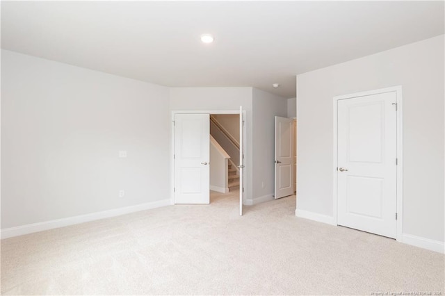 unfurnished bedroom with baseboards, recessed lighting, and light carpet