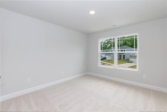 empty room with carpet floors, visible vents, recessed lighting, and baseboards