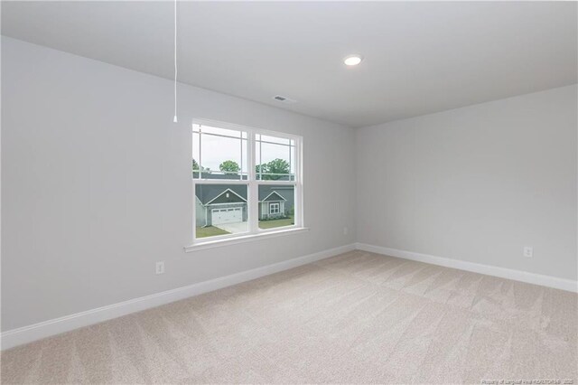 empty room featuring visible vents, baseboards, recessed lighting, and light carpet