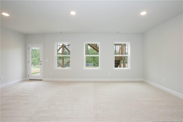 unfurnished room featuring recessed lighting, light colored carpet, and baseboards