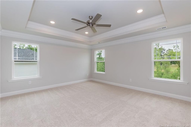 spare room with baseboards, visible vents, a raised ceiling, and crown molding