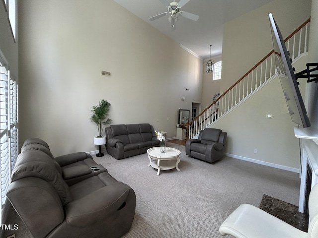 carpeted living room featuring stairway, ceiling fan, a towering ceiling, and baseboards