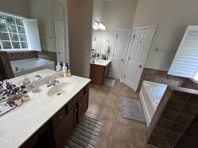bathroom featuring a garden tub, two vanities, tile patterned floors, and a towering ceiling