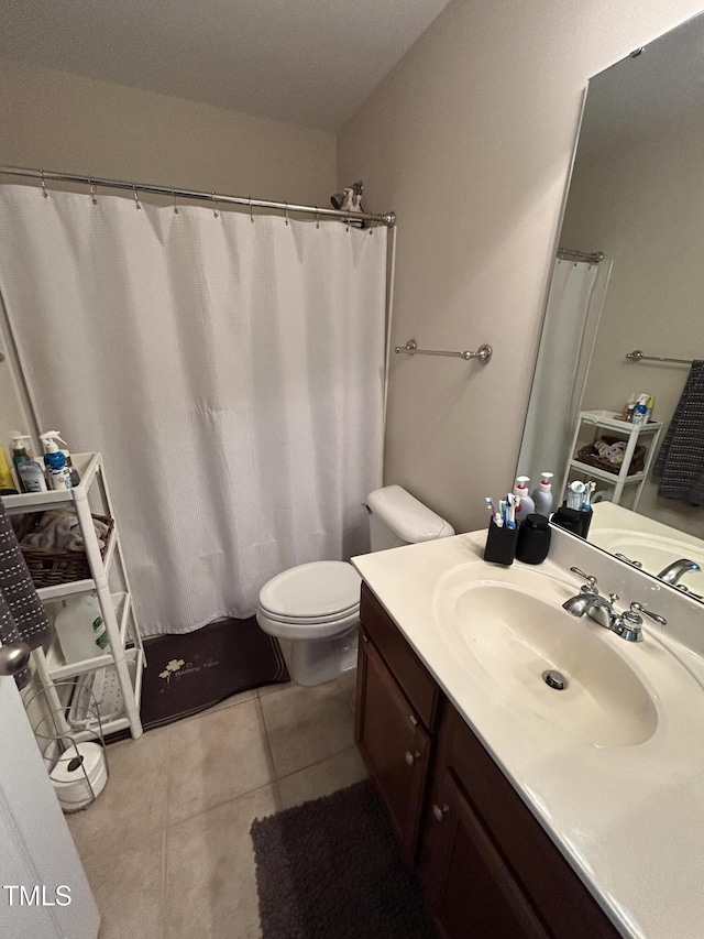 bathroom with toilet, vanity, and tile patterned floors