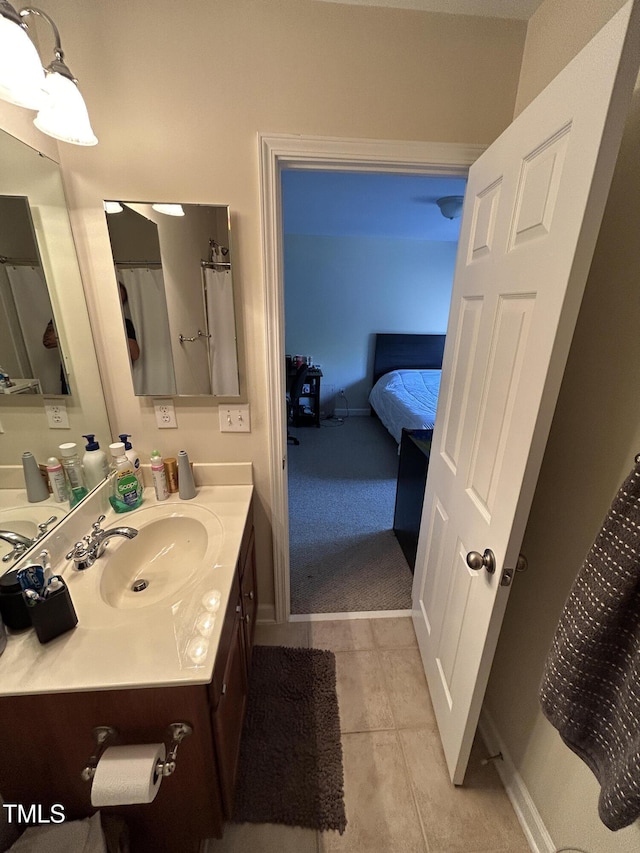 full bathroom featuring vanity, tile patterned floors, and baseboards