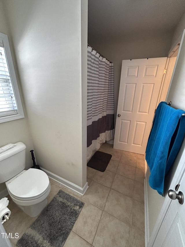 full bath with tile patterned flooring, toilet, and curtained shower