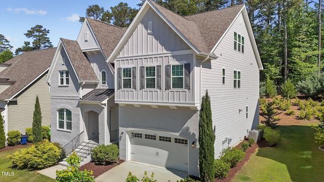 view of front of house featuring board and batten siding, a garage, a shingled roof, and concrete driveway
