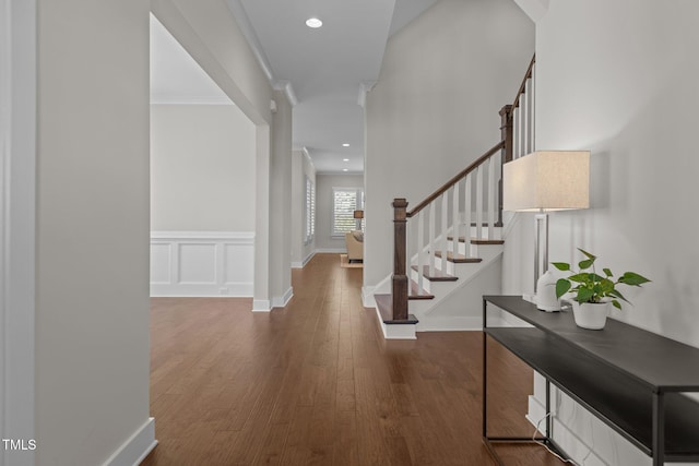 hall with wood finished floors, stairs, crown molding, and baseboards