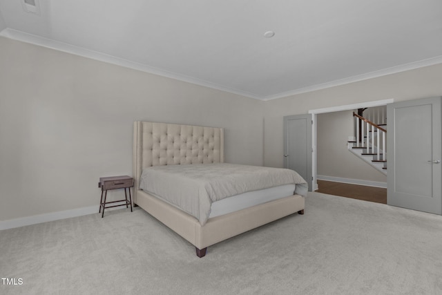 carpeted bedroom with crown molding and baseboards