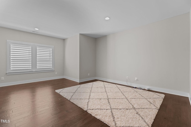 spare room with dark wood-style floors, baseboards, and recessed lighting