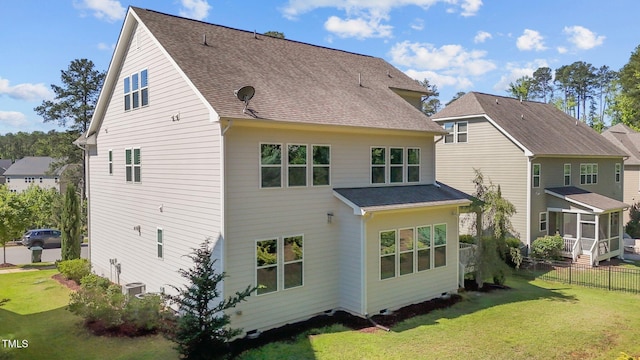 rear view of house featuring a sunroom and a shingled roof