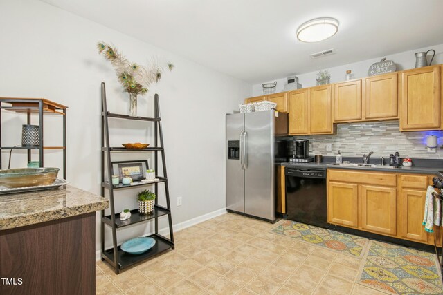 kitchen featuring a sink, black dishwasher, decorative backsplash, stainless steel refrigerator with ice dispenser, and visible vents