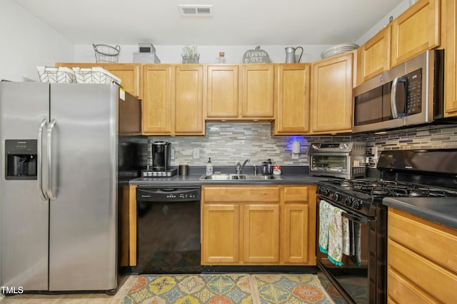 kitchen featuring visible vents, a sink, black appliances, and dark countertops