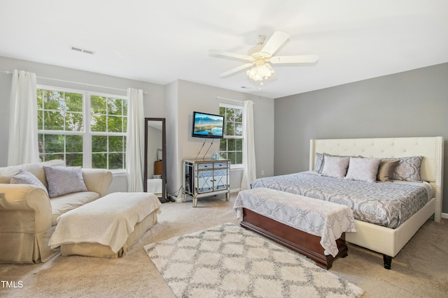 carpeted bedroom featuring visible vents and a ceiling fan