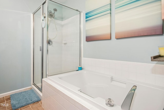 full bathroom featuring tile patterned flooring, a stall shower, and a garden tub