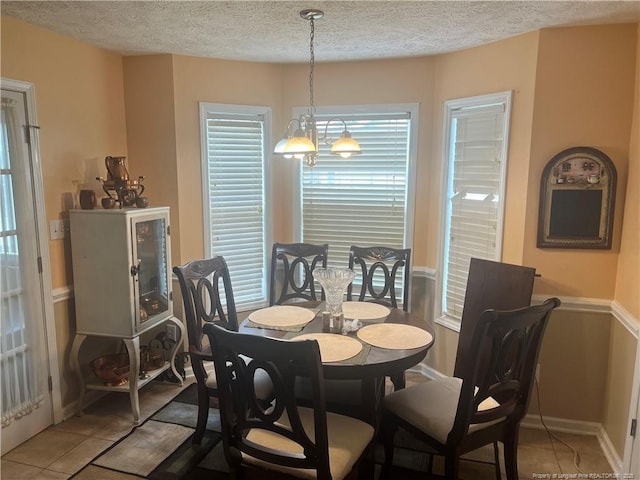 3418 Rudland Ct, Fayetteville, NC 28304 - tiled dining area featuring a textured ceiling and baseboards